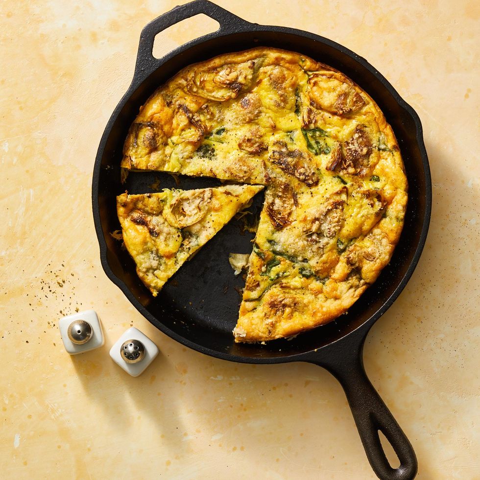 a skillet with an egg frittata and slice