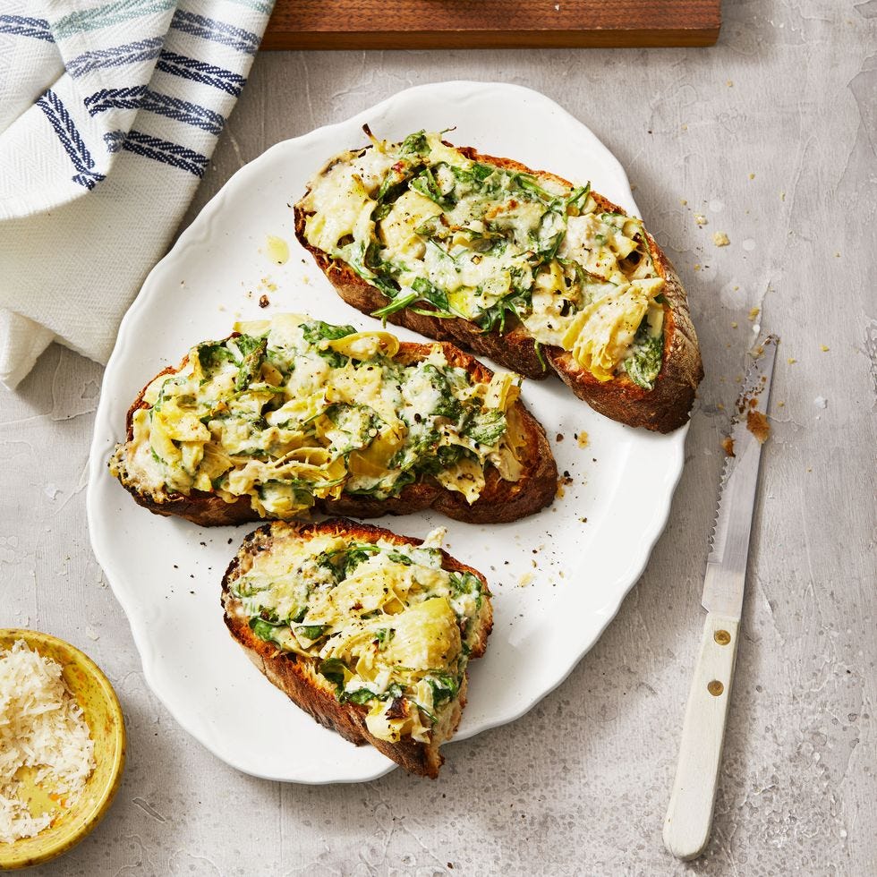 spinach artichoke tartines on a white plate