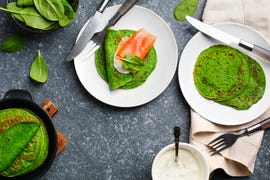 spinach crepes with smoked salmon and sour cream, top view