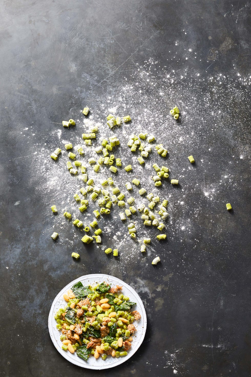 spinach macaroni with beans and greens on a white plate