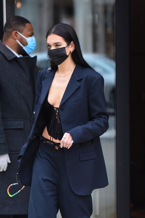 dua in a navy suit, black crop top, and black mask