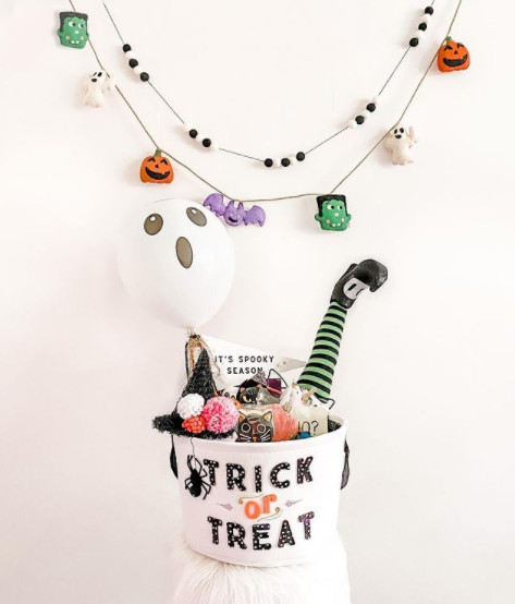 spooky basket idea from being bullard the basket has a witch hat and a witch leg with a striped sock sticking out of it
