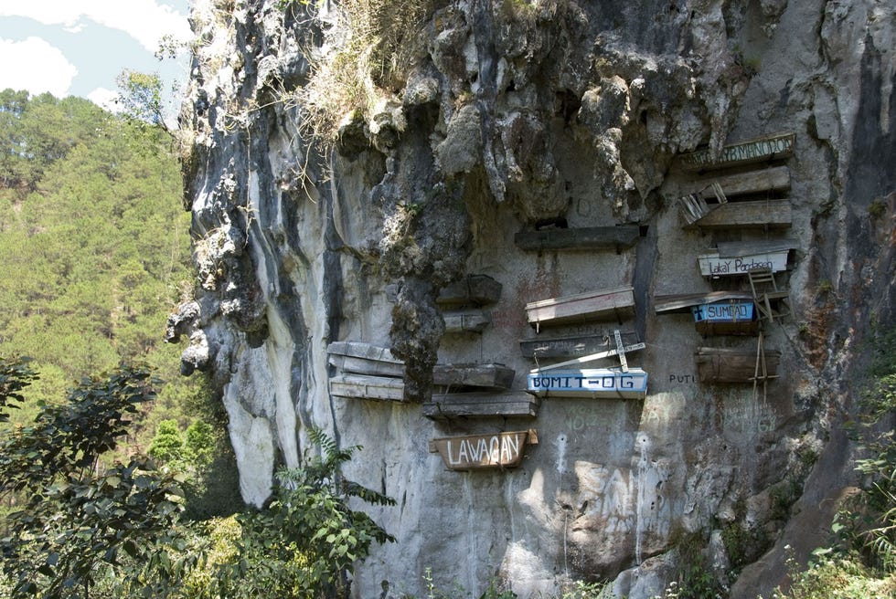 HANGENDE DOODSKISTEN FILIPIJNENLeden van de Igorotstam in de Filipijnse provincie Sagada hangen de doodskisten van hun dierbaren hoog aan de rotswand zodat die dichter bij de hemel zijn