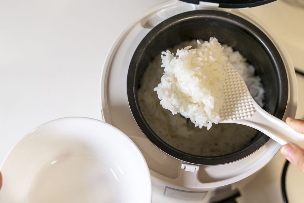 spooning rice from electric cooker