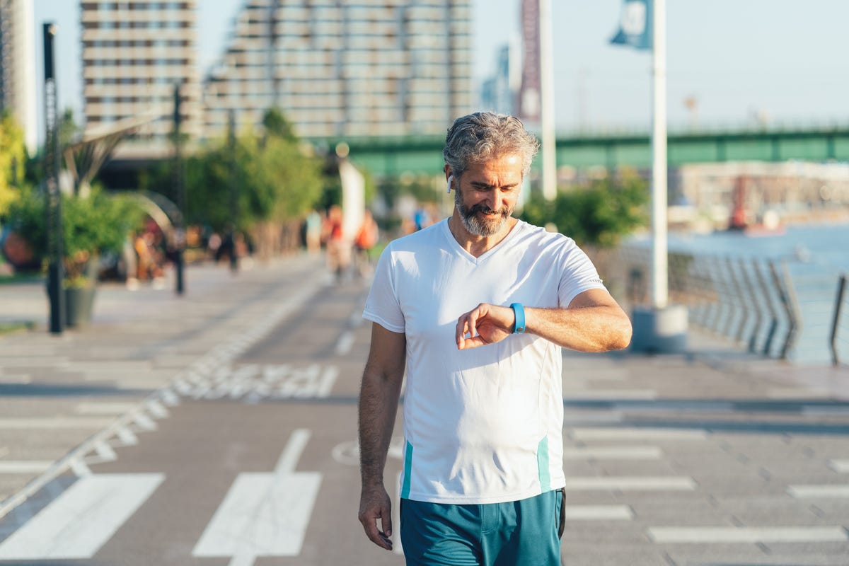 Old man walking near board with posters on street · Free Stock Photo