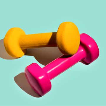 sport lifestyle concept with pink yellow dumbbells on pastel mint green background