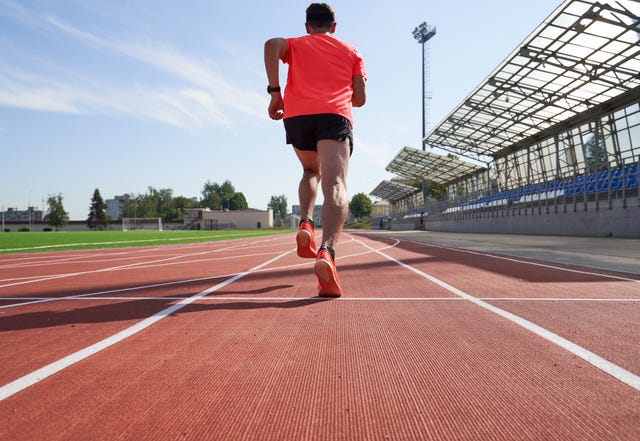 sport man athlete is running on treadmillat the stadium