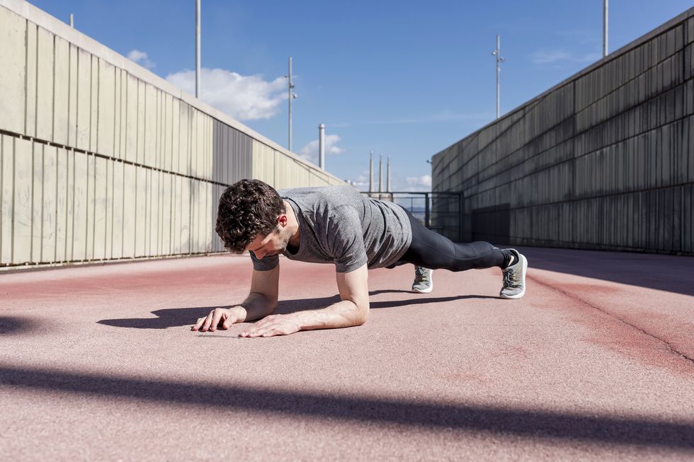 Sportive man exercising outdoors between walls