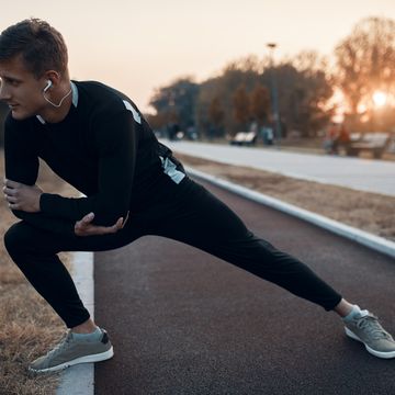 hardloper doet dynamische oefeningen tijdens zijn warming up