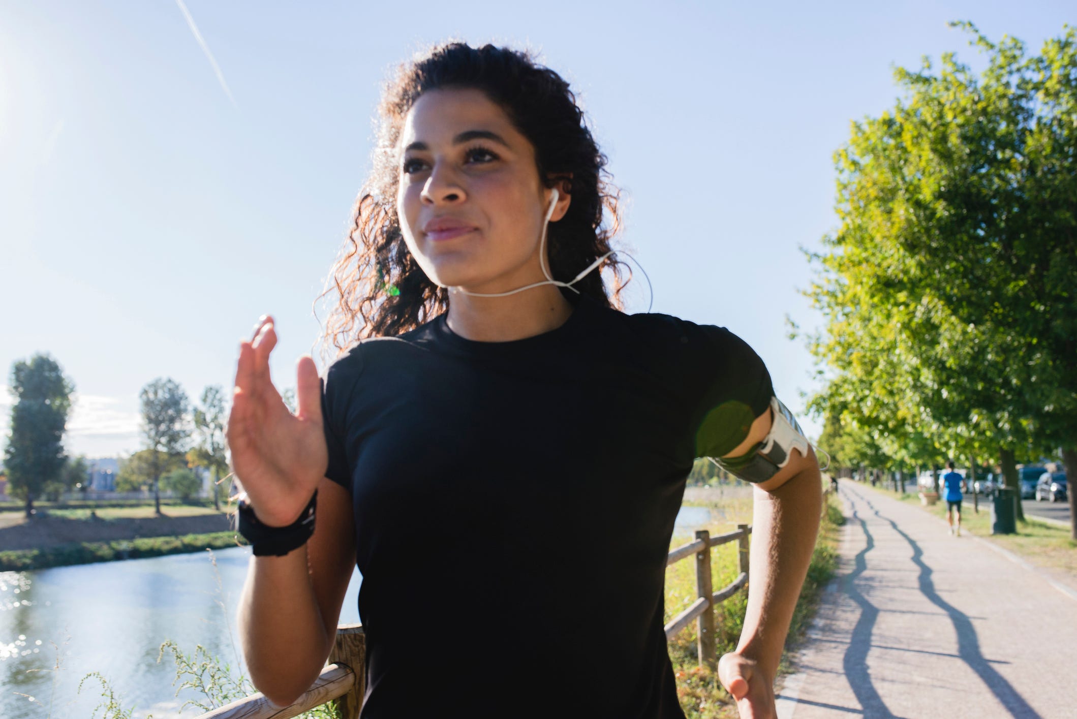 Sportive young woman running at the riverside