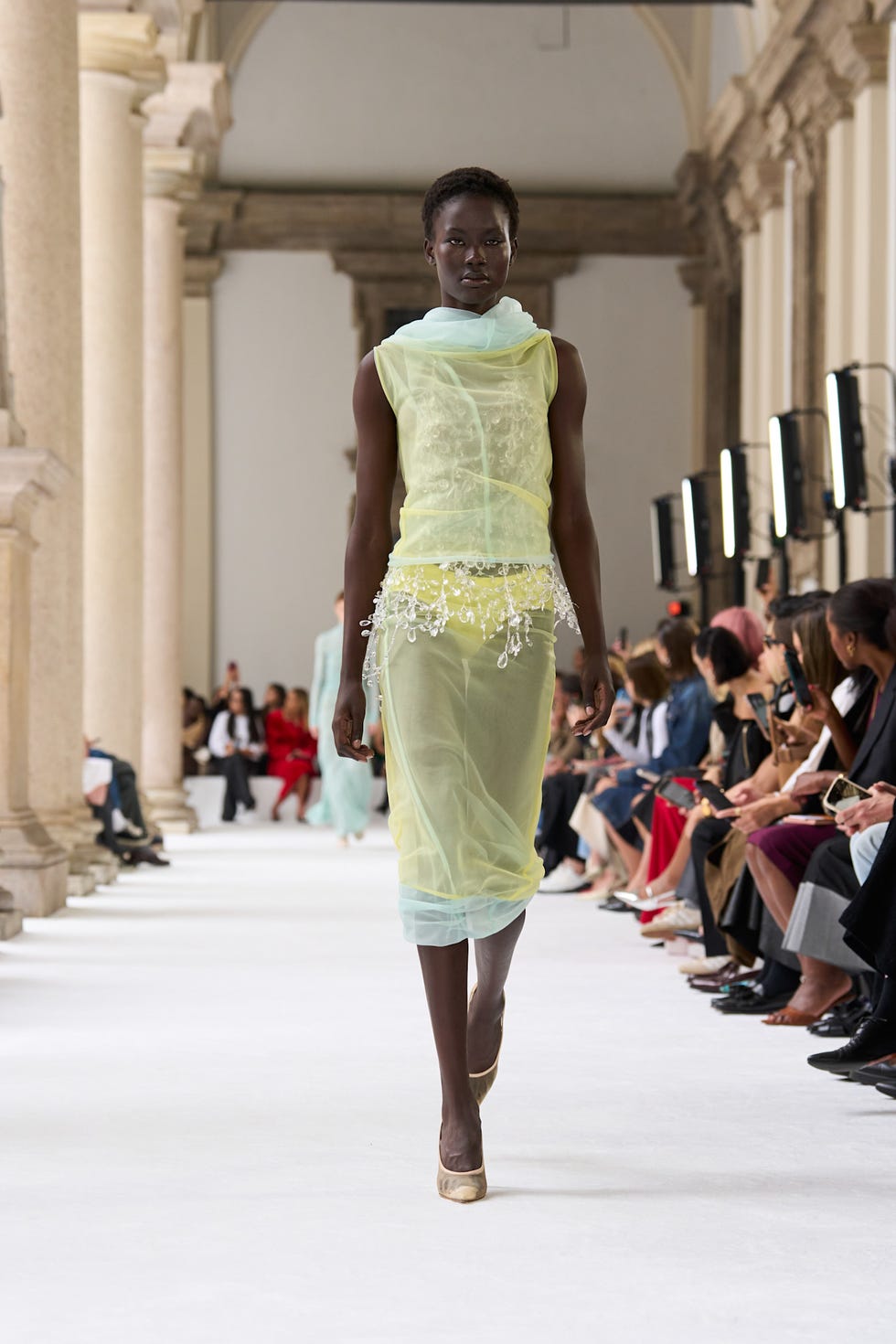 model walking down the runway in a sheer dress