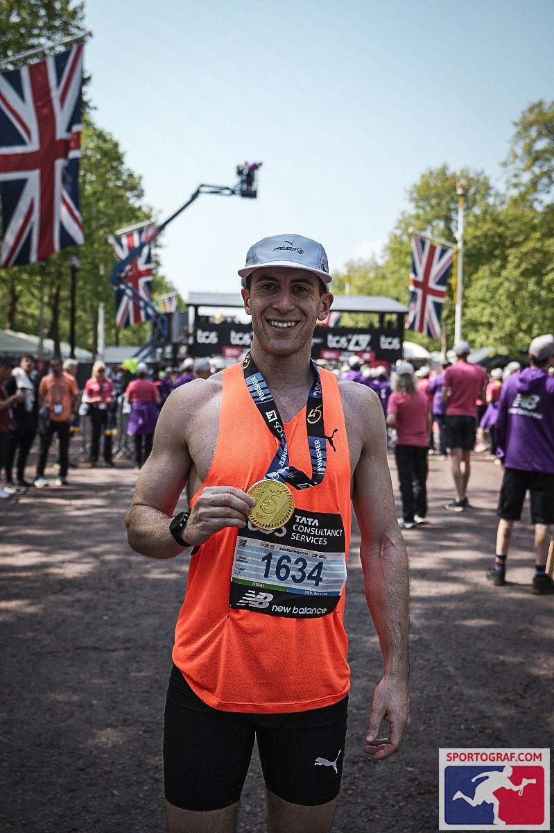 runner celebrating with a medal at the finish line of a race