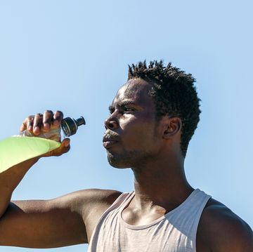 athlete drinking sports drink in water bottle