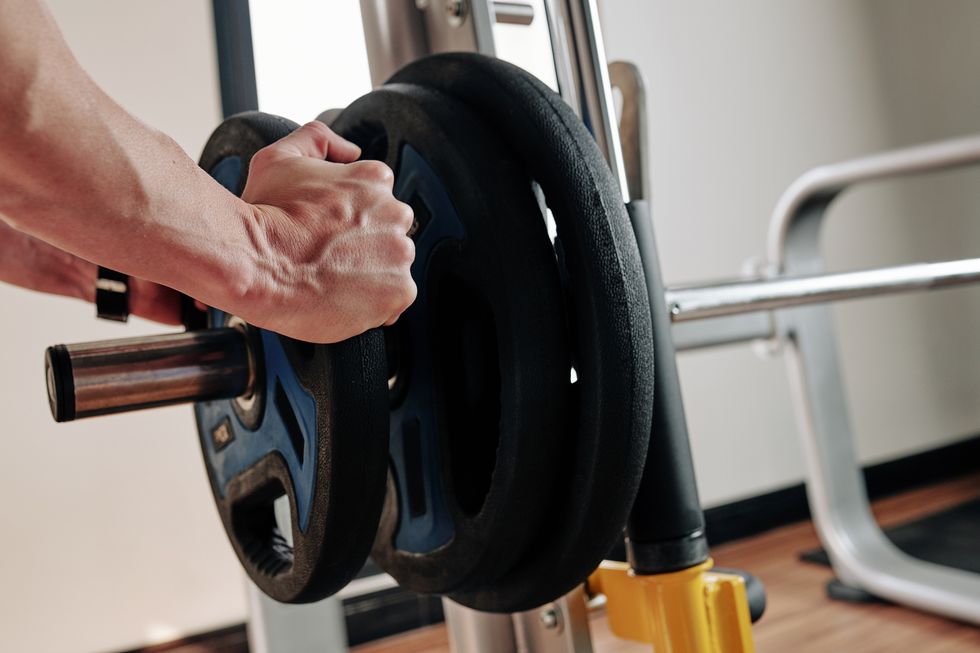 sportsman putting weight plates on barbell