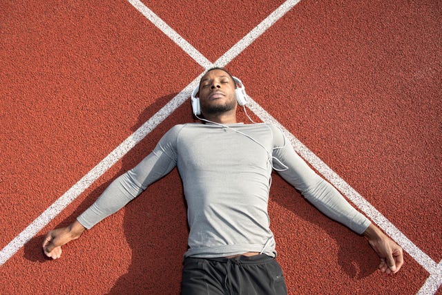 sportsman relaxing and listening to the music after workout on racetrack