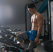 sportsman riding stationary bicycle in gym