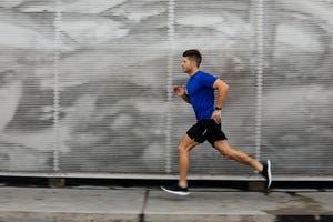 sportsman running against metal wall