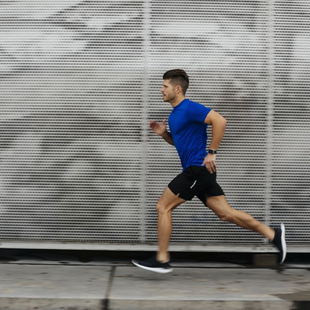 sportsman running against metal wall