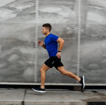 sportsman running against metal wall