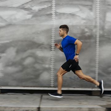 sportsman running against metal wall