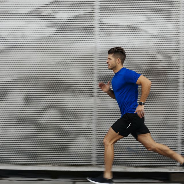 sportsman running against metal wall