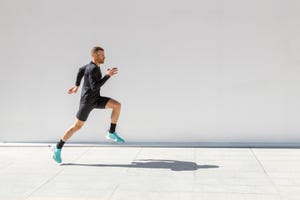 sportsman running on footpath during sunny day