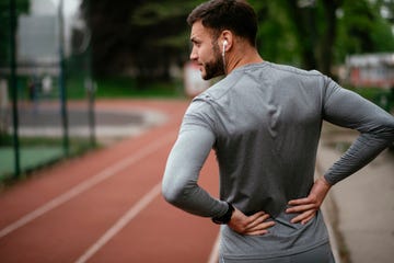 sportsman suffering from backache at park outdoors