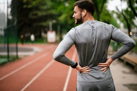 sportsman suffering from backache at park outdoors