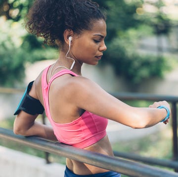 Sportswoman checking her smart watch july playlist