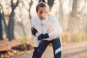 vrouw in sportkleding buiten kijkt op horloge