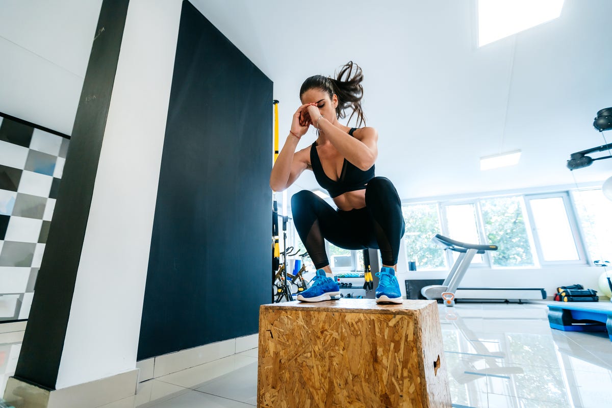 Young Sportswoman Doing Warm-up Balance Exercise Standing On One