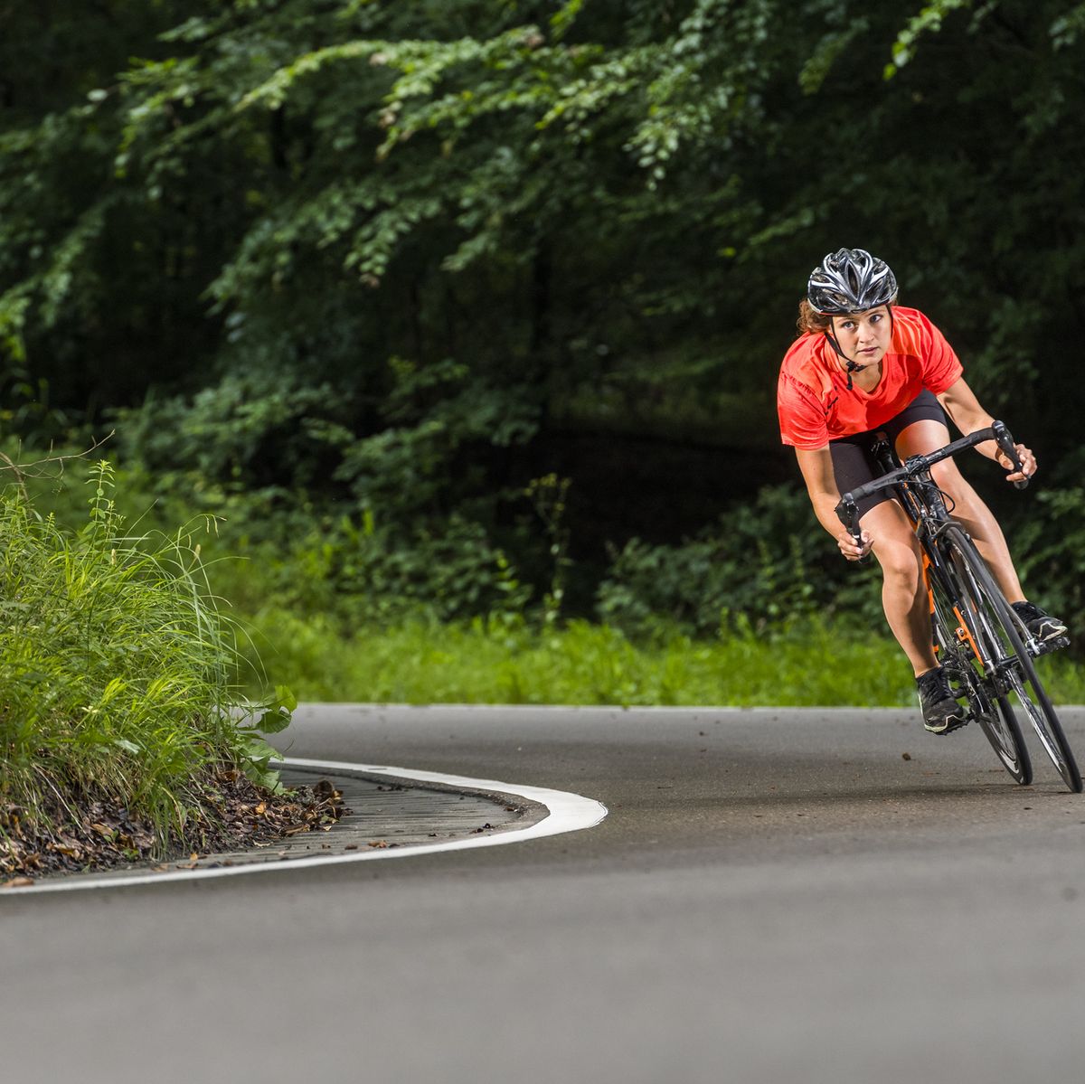 sportswoman exercising on racing bicycle at forest, hiit bike workouts
