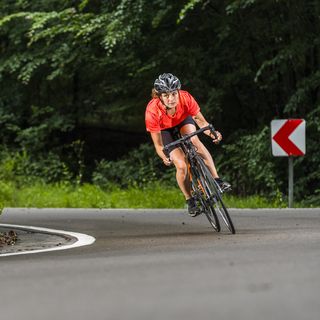 sportswoman exercising on racing bicycle at forest, hiit bike workouts