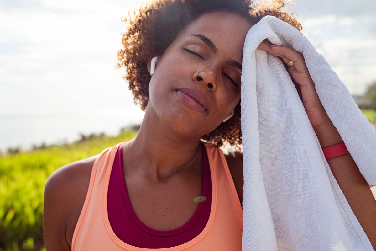 sportswoman wipes sweat from her face after outdoor training