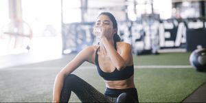 Vrouw in de gym, drinkt water
