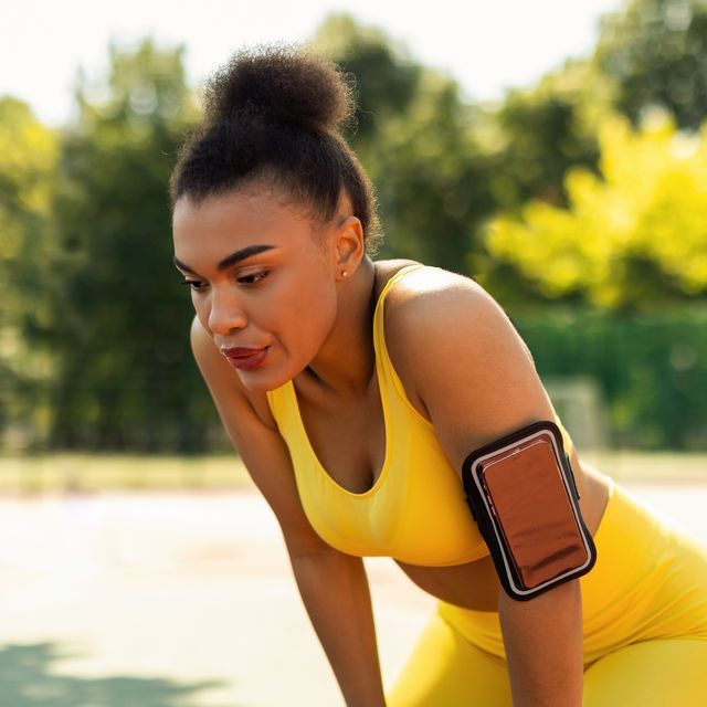 nasal breathing while running sporty black woman in yellow sportswear resting after run