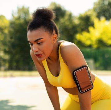 nasal breathing while Weight running sporty black woman in yellow sportswear resting after run