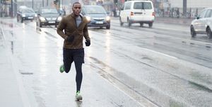sporty man jogging LEATHER rainy city scape