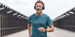 sporty man wearing headphones and jogging