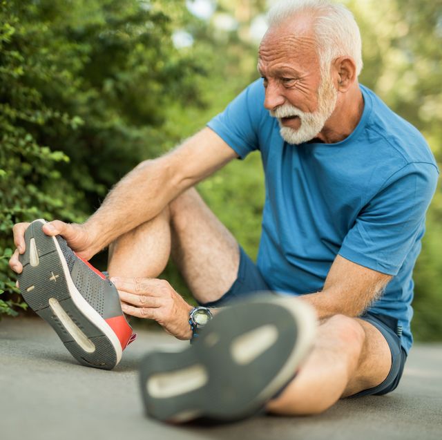 sporty senior man having leg injury outdoors