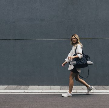 sporty woman in a white sweatshirt walking in city
