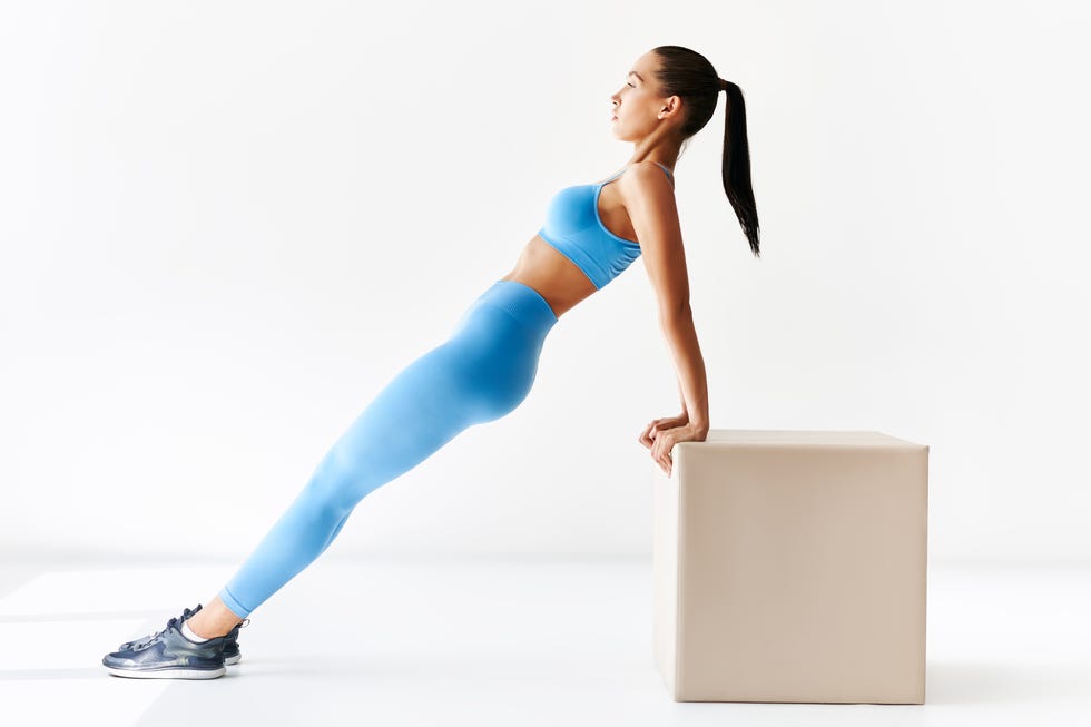 sporty woman making reverse plank exercise on white background, pelvic tilt