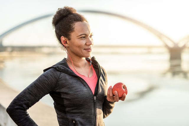 een vrouw eet een appel na het sporter