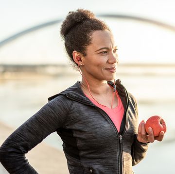 een vrouw eet een appel na het sporter