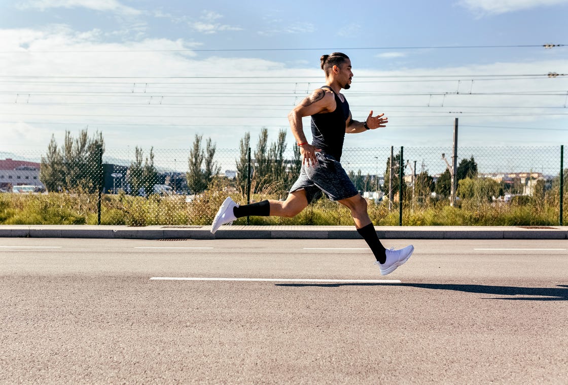 sporty young man running on a road