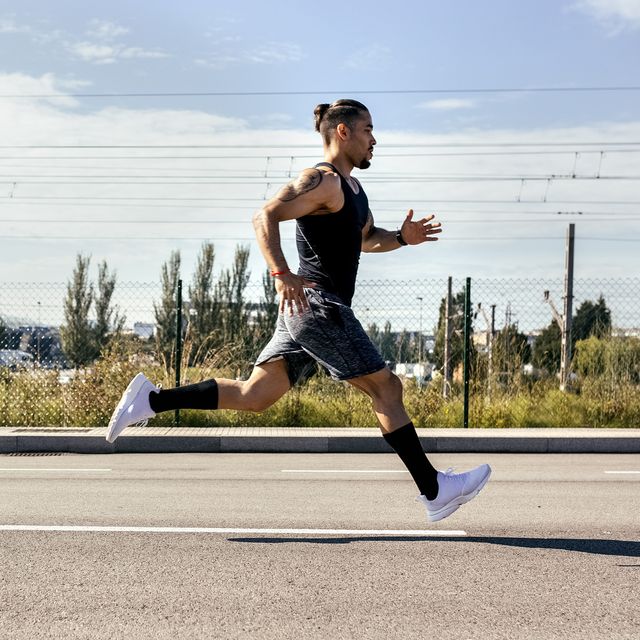 sporty young man running on a road