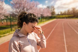 sporty young woman having a headache