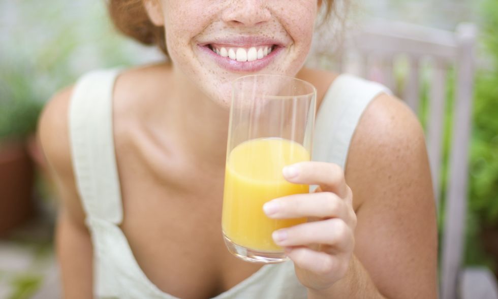 Young Redheaded Woman drinking orange Juice