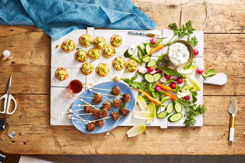 spring crudités with herbed cheese dip with fresh vegetables on a cutting board