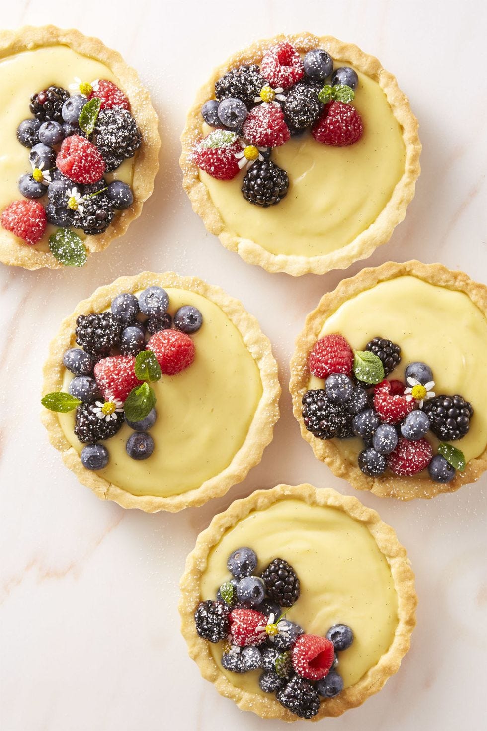 a close up of berry cream tartlets